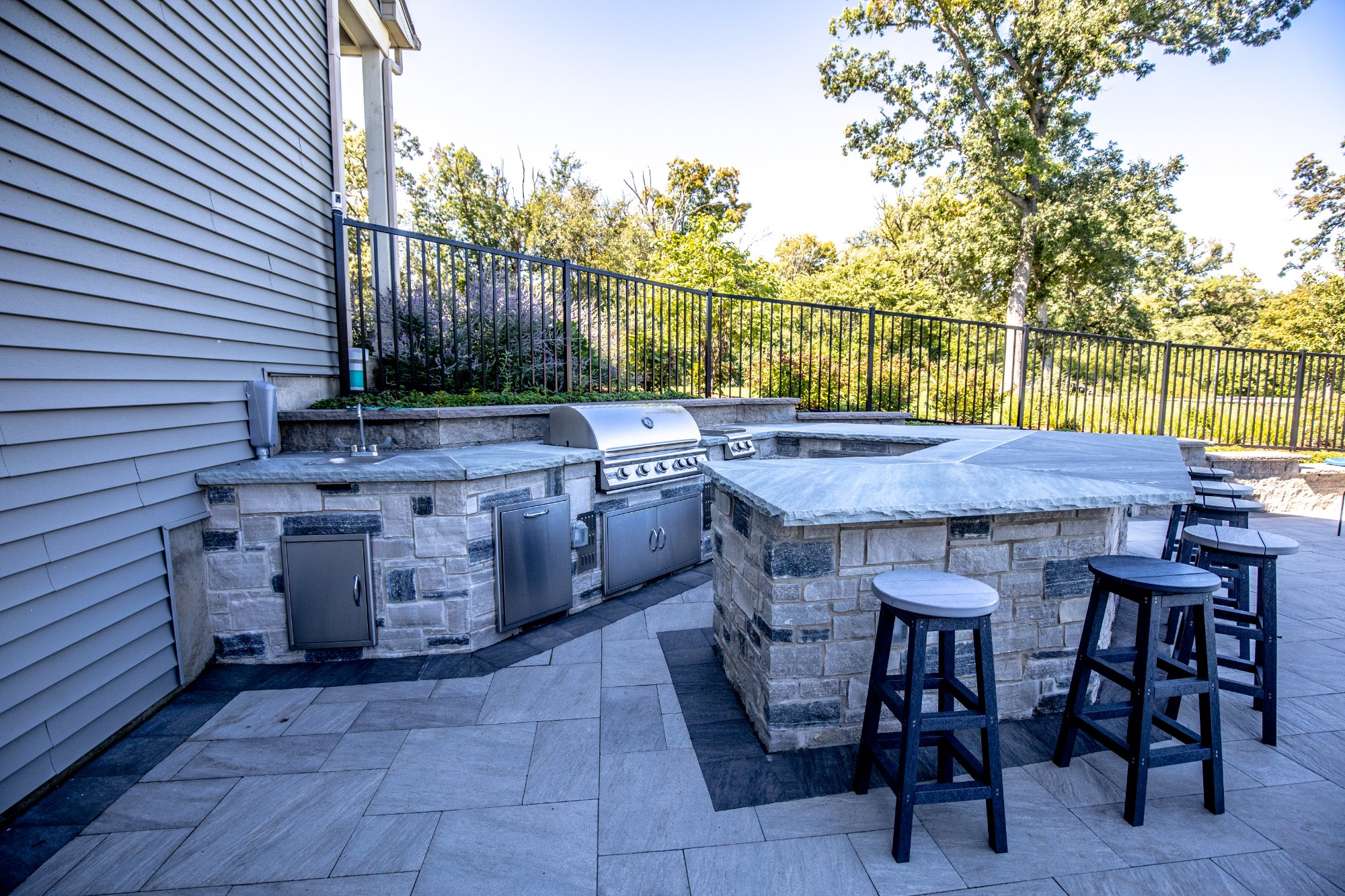 Custom outdoor kitchen with built-in grill sink and bar seating North Shore IL